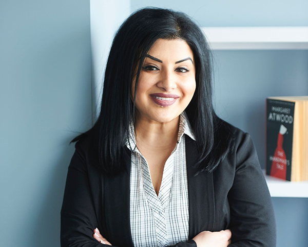 Dr. Bharathi Sandhu. Margaret Atwood's novel, The Handmaid's Tale, is visible on the shelf behind her.