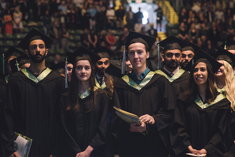 A line of graduands smile while they wait to be seated at the ceremony.