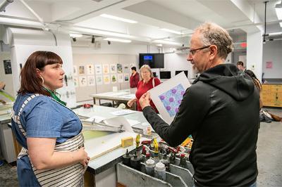 Two people engaged in a discussion in an art room.