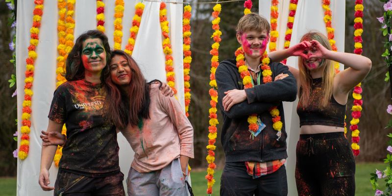 UFV students celebrating Holi, covered in colourful powder.