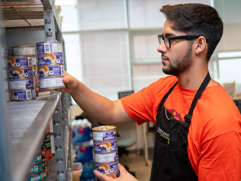 A student volunteer stocks the food bank shelves at UFV.