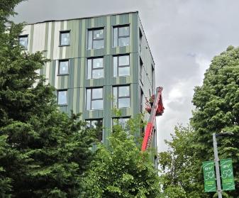 Building J visible as construction worker clads the building exterior.