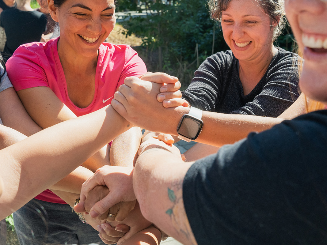 A group of students clasping hands