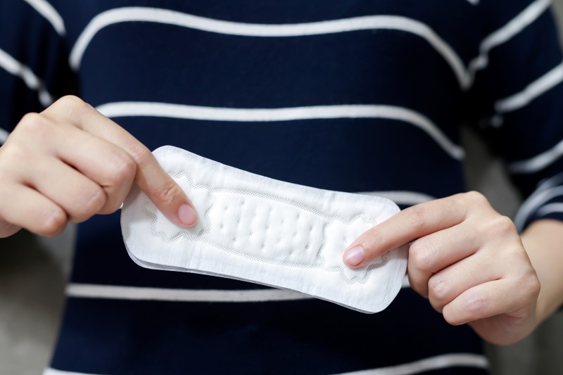 Hands holding up a menstrual pad