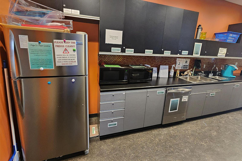 A kitchen with cabinets and refrigerator.