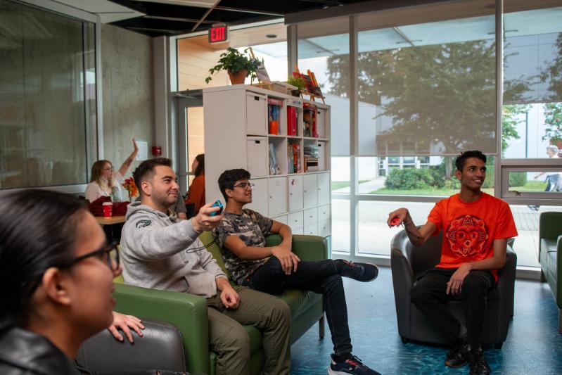 A group of people sitting on couches playing video games.