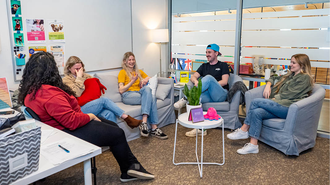 A group of students talking and laughing at the Wellness Centre