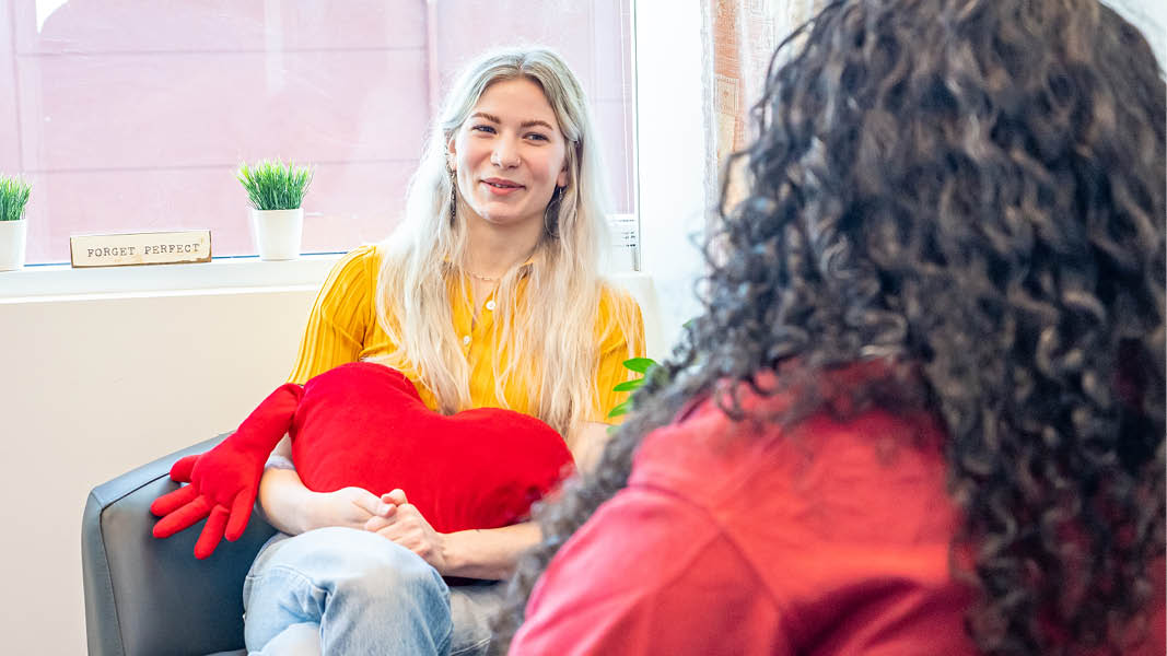 Student hugging a heart pillow and chatting