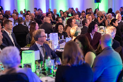 Guests are seated around a table enjoying the after-dinner program at Town & Gown.