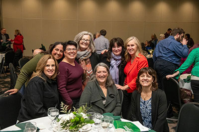 Group of people at the UFV Retirement dinner, standing and smiling.